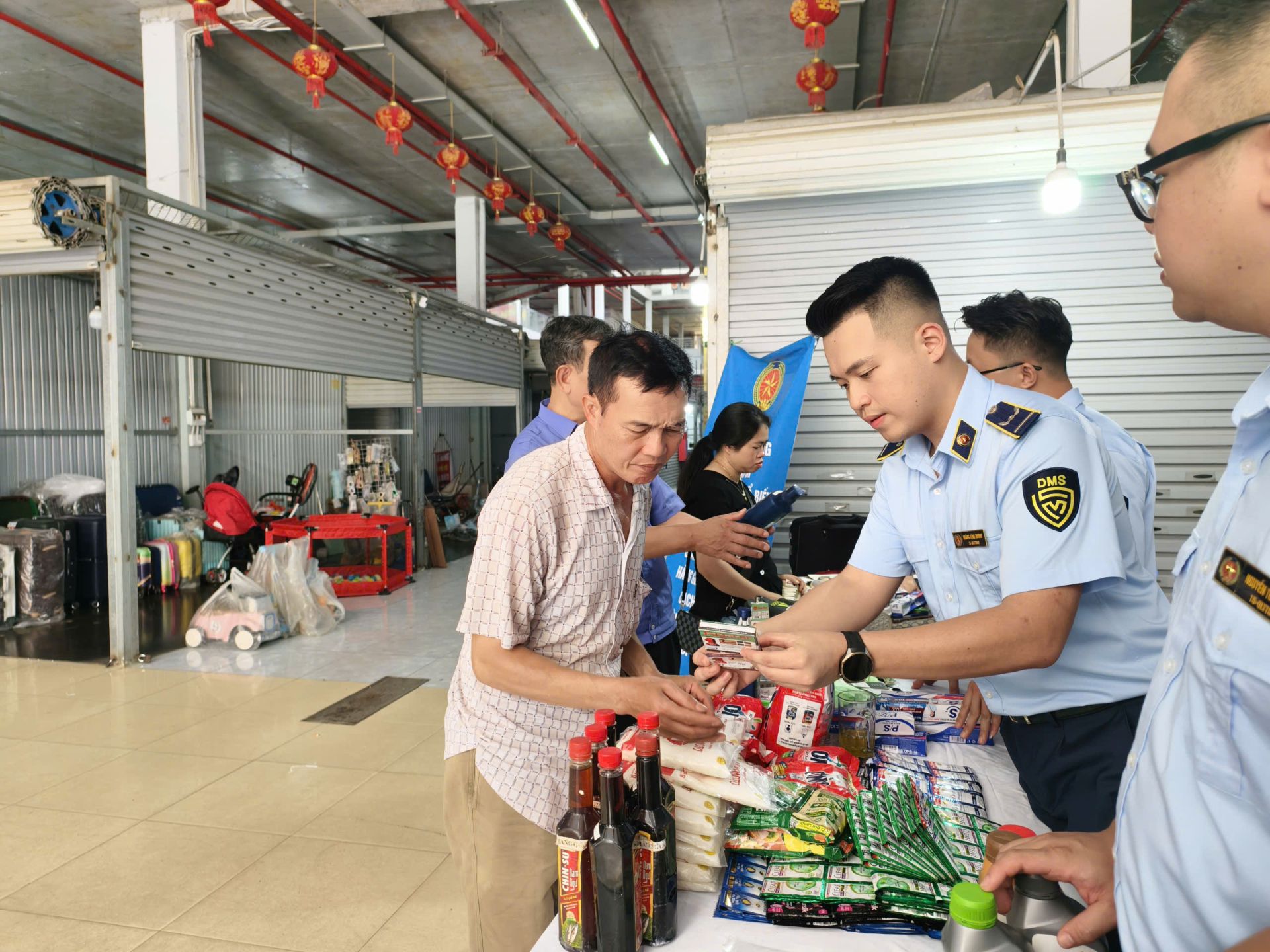 Công chức Quản lý thị trường hướng dẫn người dân nhận biết hàng thật và hàng giả